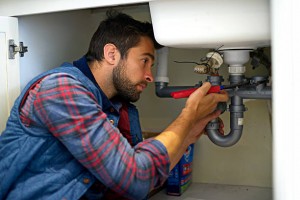 Shot of a plumber fixing a pipe
